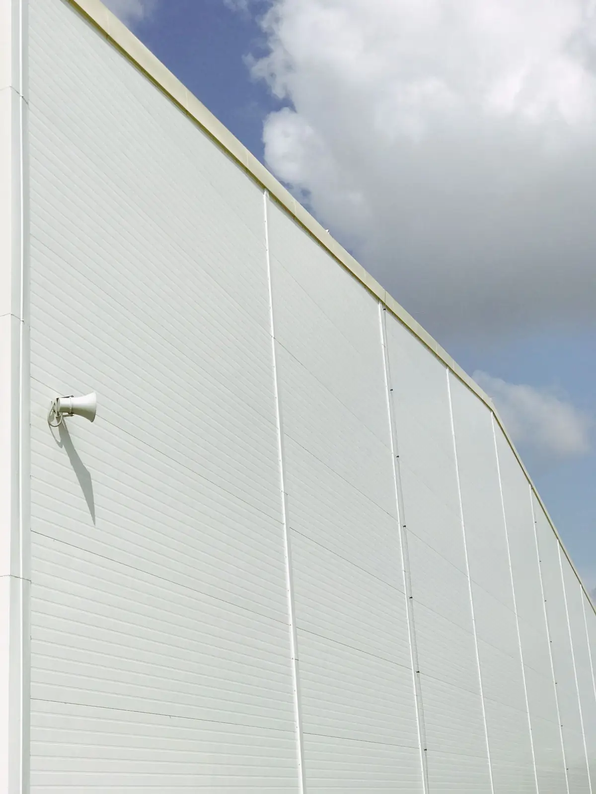 White insulated panel facade against the sky