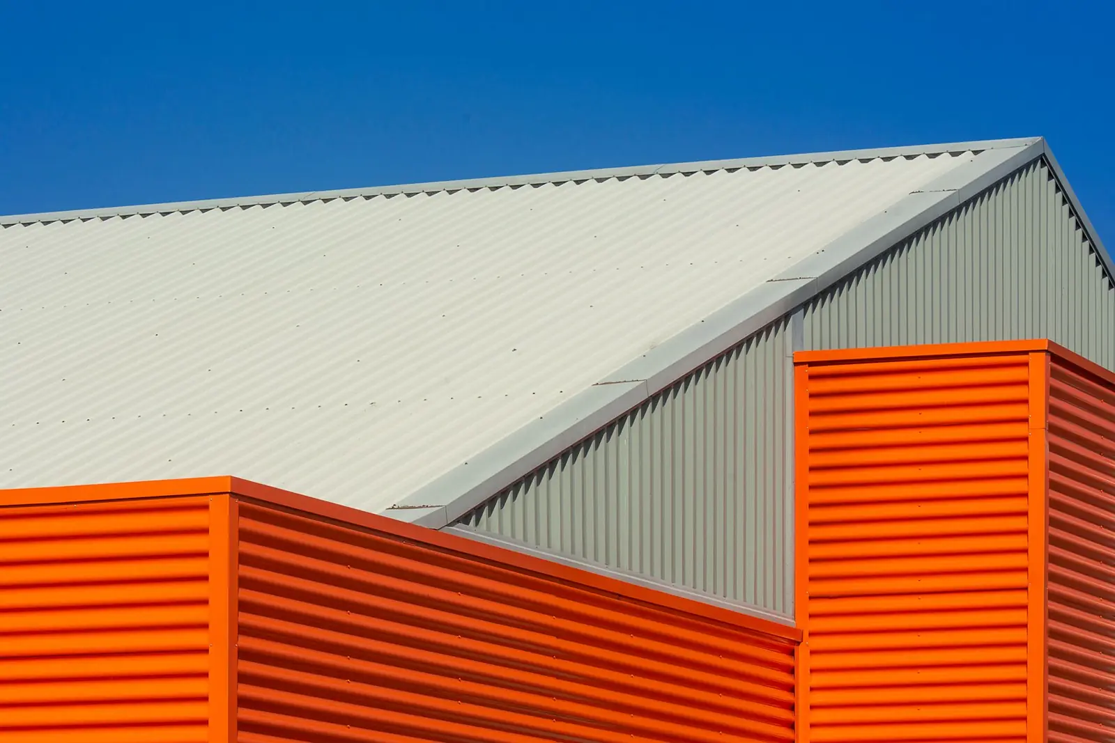 Orange wall panels under a white profiled roof